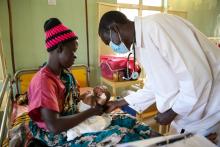 Dr. James Aldino untersucht den kleinen Malaria-Patienten Francis